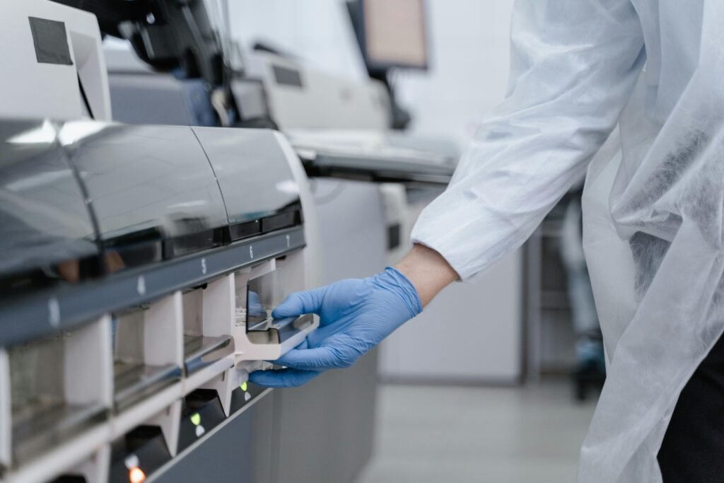 Lab technician in a white coat using equipment with precision in a sterile environment.